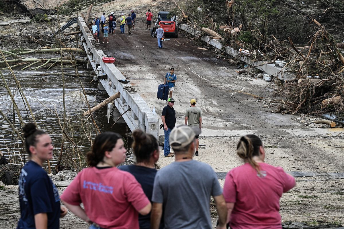 People look on as law enforcement and volunteers continue to search for missing people near Camp Mystic after flash flooding in Hunt, Texas, on Saturday, July 5, 2025. (Ronaldo Schemidt/AFP/Getty Images/TNS) (Ronaldo Schemidt/AFP/Getty Images North America/TNS)