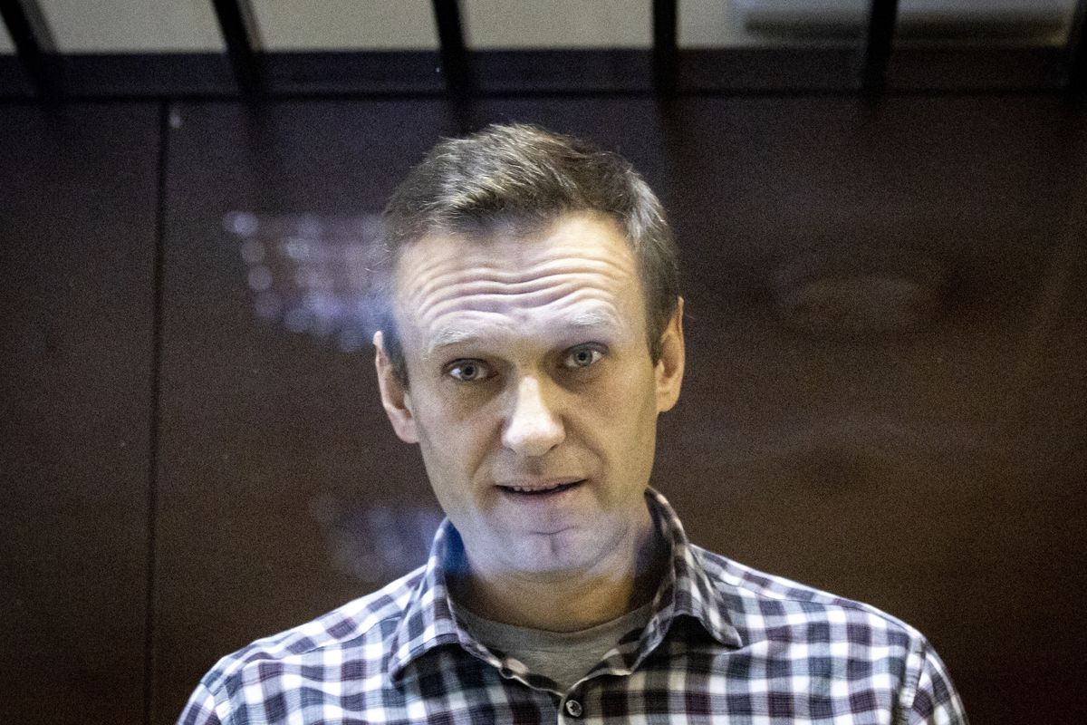 In this photo taken on Saturday, Feb. 20, 2021, Russian opposition leader Alexei Navalny looks at photographers standing behind a glass of the cage in the Babuskinsky District Court in Moscow, Russia. Alexei Navalny says on Wednesday, March 31 he has started a prison hunger strike to protest officials