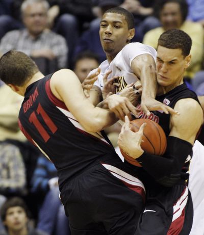 Stanford’s Dwight Powell, right, and Andy Brown battle with California’s Richard Solomon. (Associated Press)