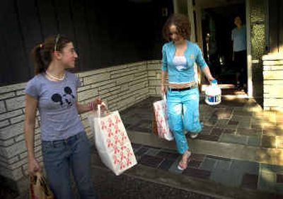 
As part of their tzedakah (giving community service), Louise Fix, 13, left, and Sarah Kleinstein, 17, pick up bags of donated food.  
 (Colin Mulvany / The Spokesman-Review)