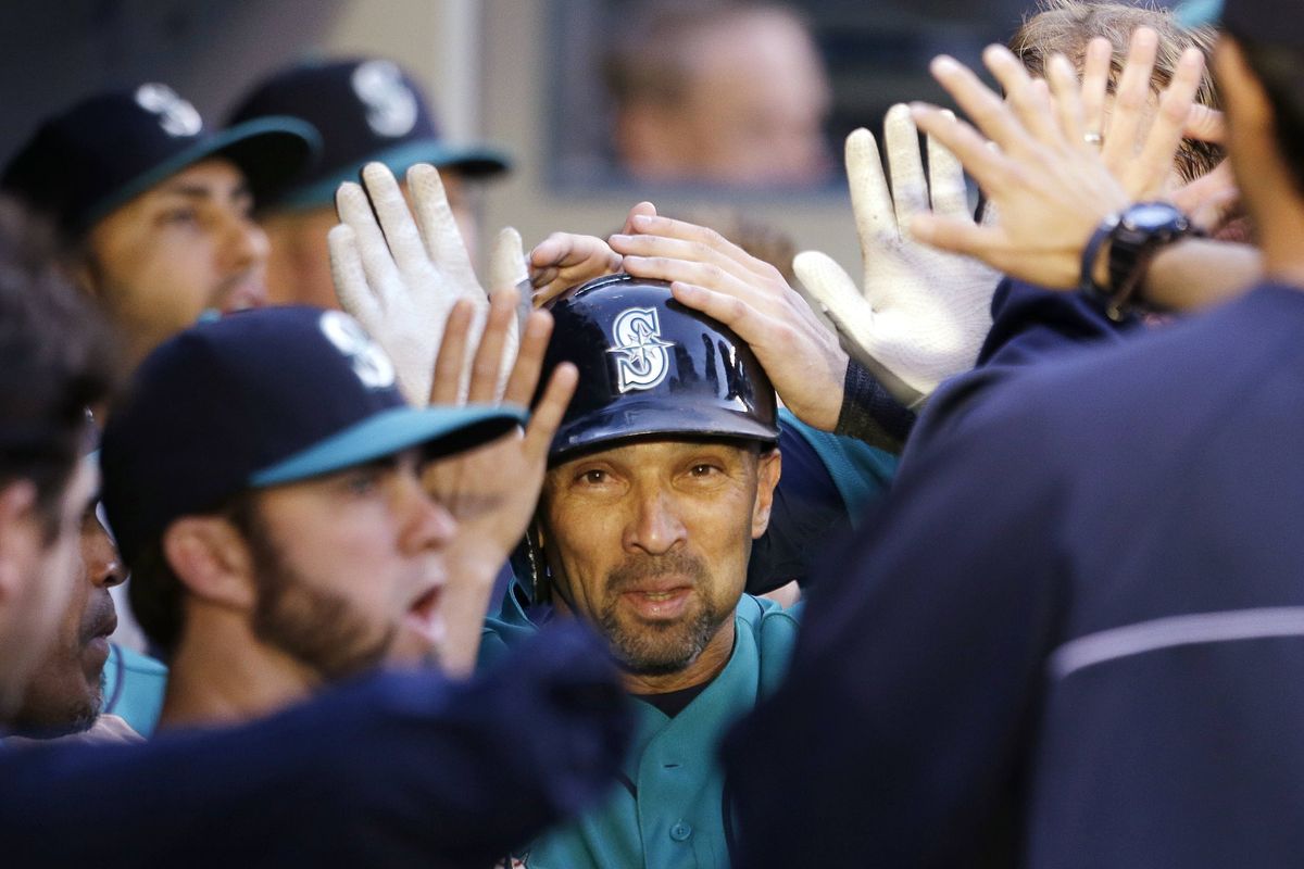 Seattle Mariners teammates congratulate Raul Ibanez after one of his two home runs against the Los Angeles Angels on Friday night. (Associated Press)