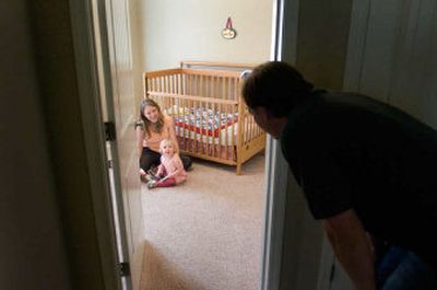 
Scott Marquis checks in on his wife, Jennifer, and daughter, Livia, as they prepare for a nap. Jennifer uses books, baths and cuddles as a routine for her two daughters. 
 (CHRISTOPHER ANDERSON / The Spokesman-Review)