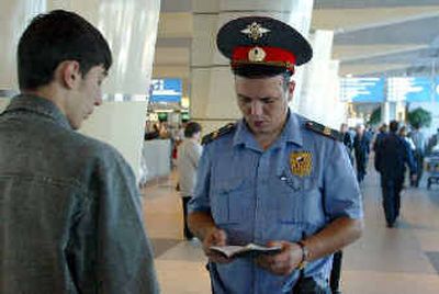 
A police officer checks ID papers Thursday at Moscow's Domodedovo airport.
 (Associated Press / The Spokesman-Review)