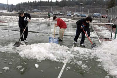 
In order for spring sports to start for Spokane Valley schools, the season needs to cooperate. The East Valley tennis team took to the court Monday with shovels rather than  rackets to help speed up the process. From left, Drew Keller, Greg Miskin and Austin Campbell bust loose ice and snow. 
 (J. BART RAYNIAK / The Spokesman-Review)