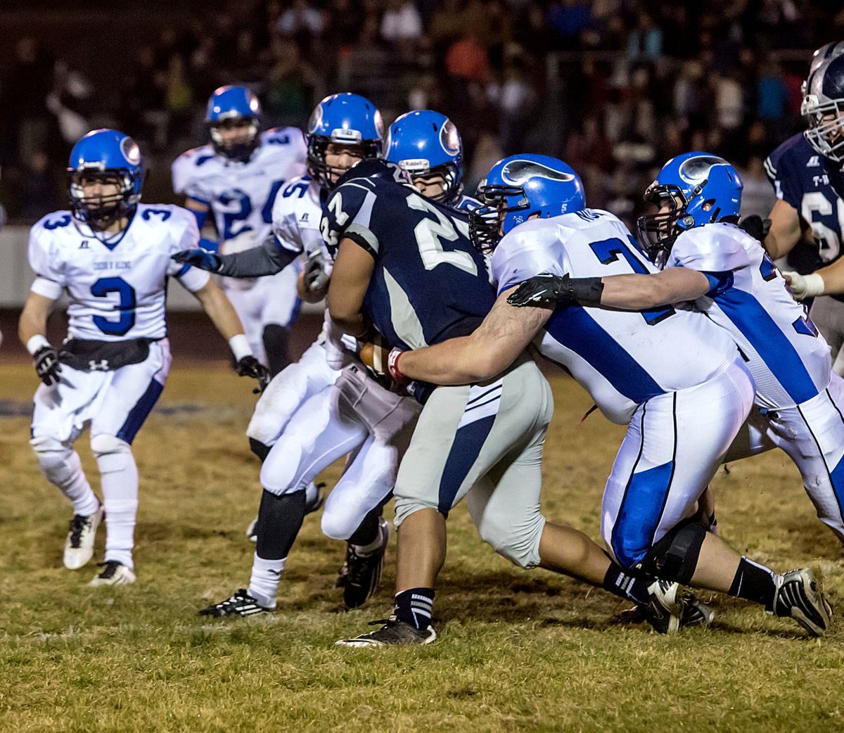 The Coeur d’Alene defense swarms over Lake City’s Gavan Rosteck in the first quarter Friday night at Lake City High School. (BRUCE TWITCHELL)