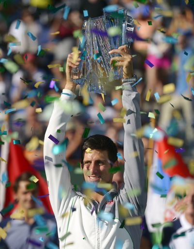 Novak Djokovic shows off trophy after victory in final over Roger Federer. (Associated Press)