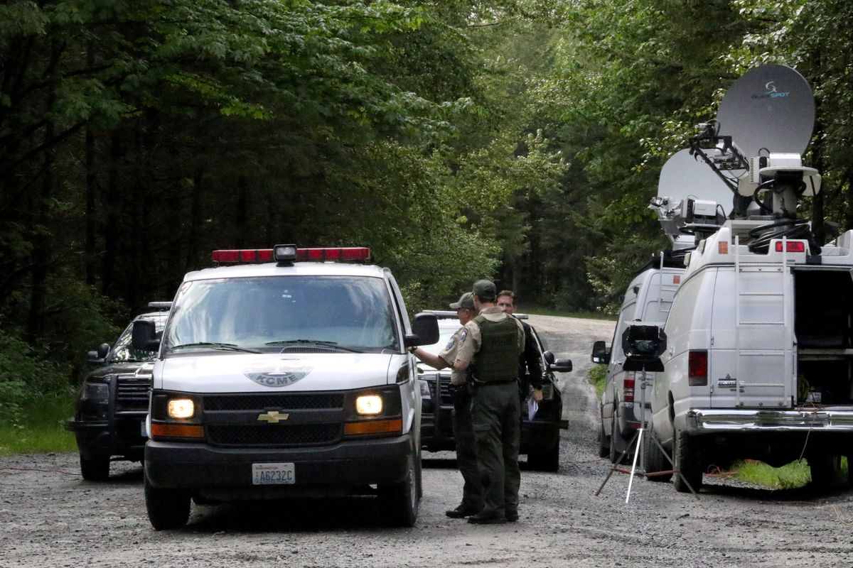FILE - Washington State Fish and Wildlife Police confer with an individual from the King County Medical Examiner