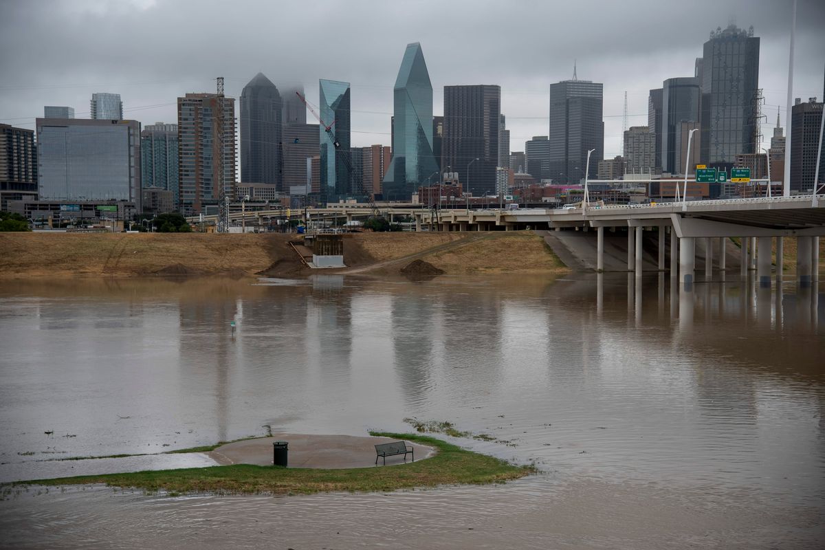 A seating area is encircled by floodwater on Aug. 22 near in the area of the Trinity River near Dallas.  (Emil Lippe/For The Washington Post)