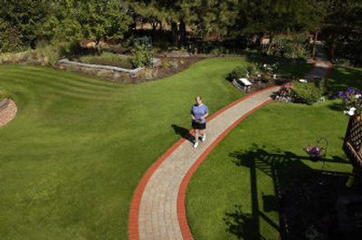 
Kathie Scott returns with fresh cut flowers from her garden along the brick path that snakes through their manicured lawn. 
 (photos by Brian PLonka/the spokesman-review / The Spokesman-Review)