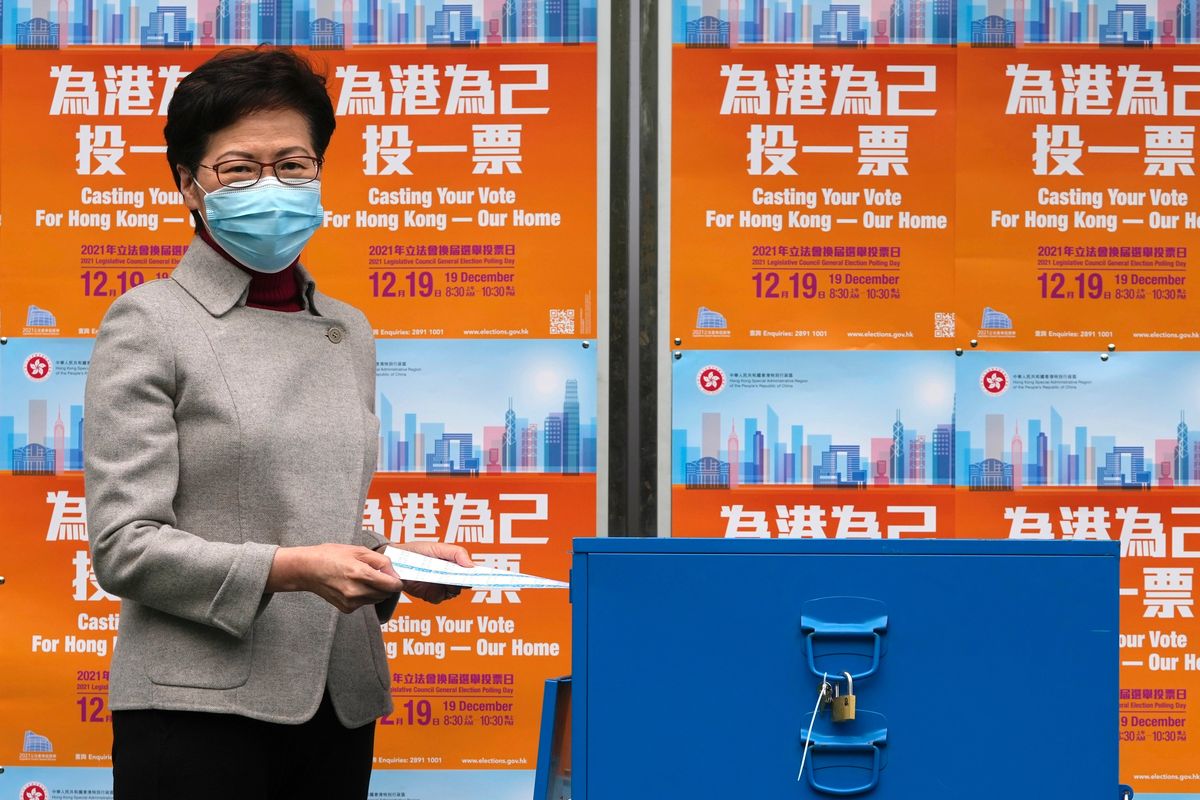 Hong Kong Chief Executive Carrie Lam poses as she casts her ballot at a polling station for the Legislative election in Hong Kong, Sunday, Dec. 19, 2021. Hong Kong was voting Sunday in the first election since Beijing amended the laws that reduced the number of directly elected lawmakers and vetted candidates to ensure that only those loyal to China can run.  (Kin Cheung)