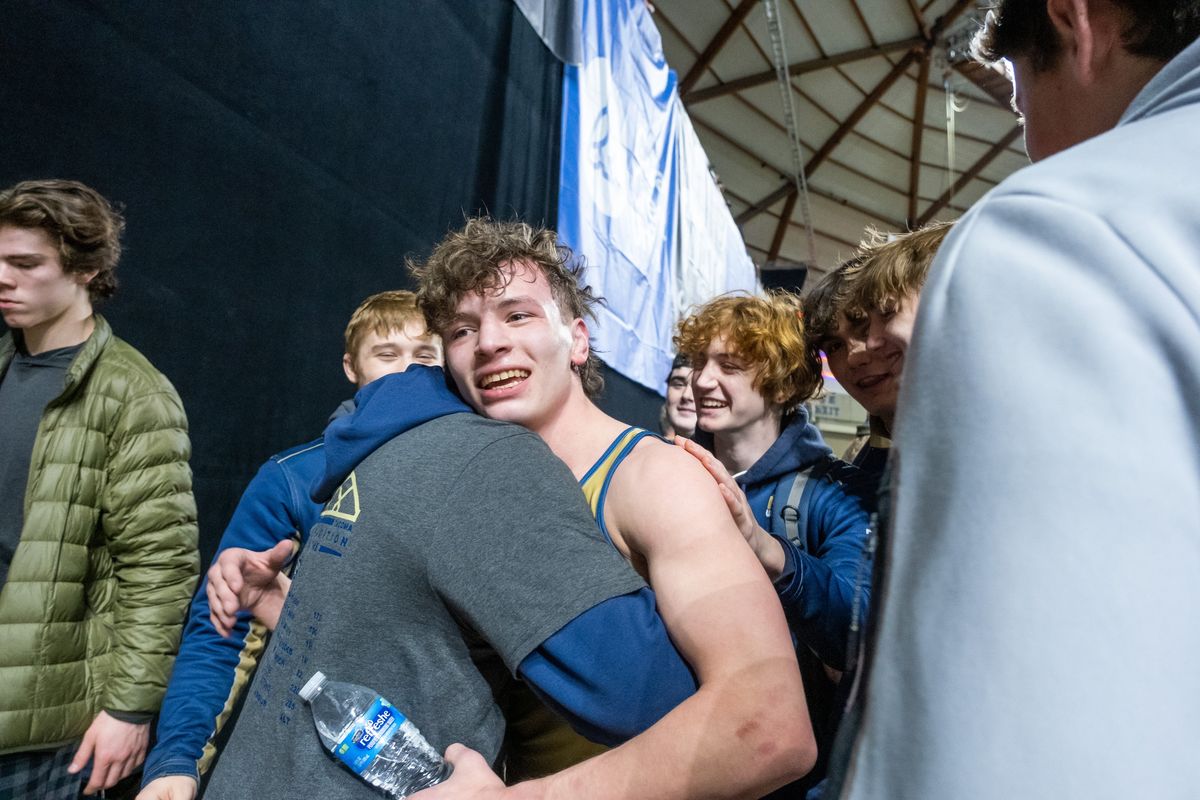 Mead’s Josh Neiwert, facing, is embraced after winning the 132-pound 3A state title at Mat Classic XXXIV on Saturday at the Tacoma Dome.  (Madison McCord / The Spokesman-Review)
