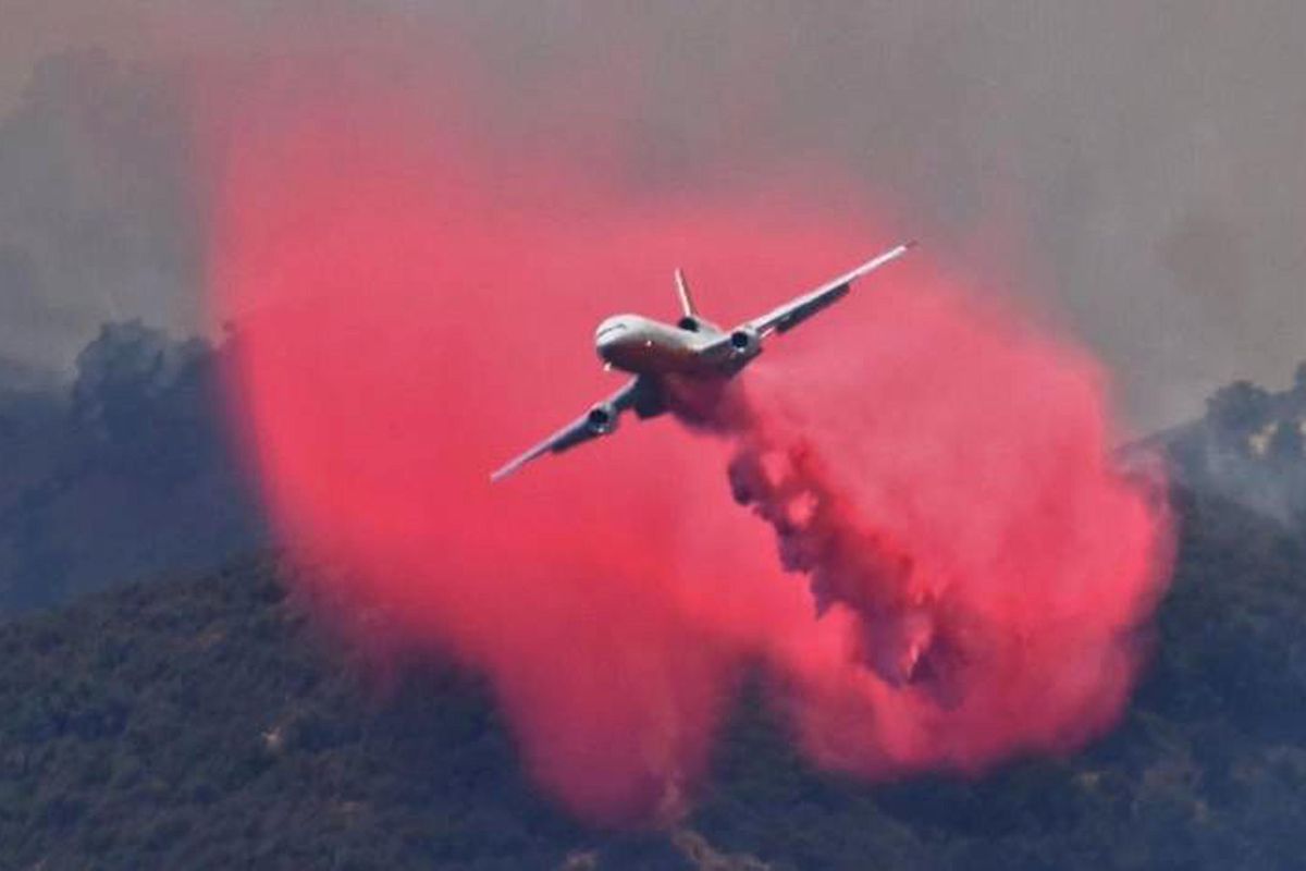 This Saturday, July 8, 2017, photo released by the Santa Barbara County Fire Department shows a DC-10 making a fire retardant drop on a ridgeline along the eastern flank of the Alamo fire in Santa Barbara County, Calif. Wildfires barreled across the baking landscape of the western U.S. and Canada, destroying a smattering of homes, forcing thousands to flee and temporarily trapping children and counselors at a California campground. Southern California crews hope slightly cooler temperatures and diminishing winds will help in the battle Sunday. (Mike Eliason / Santa Barbara County Fire Department)