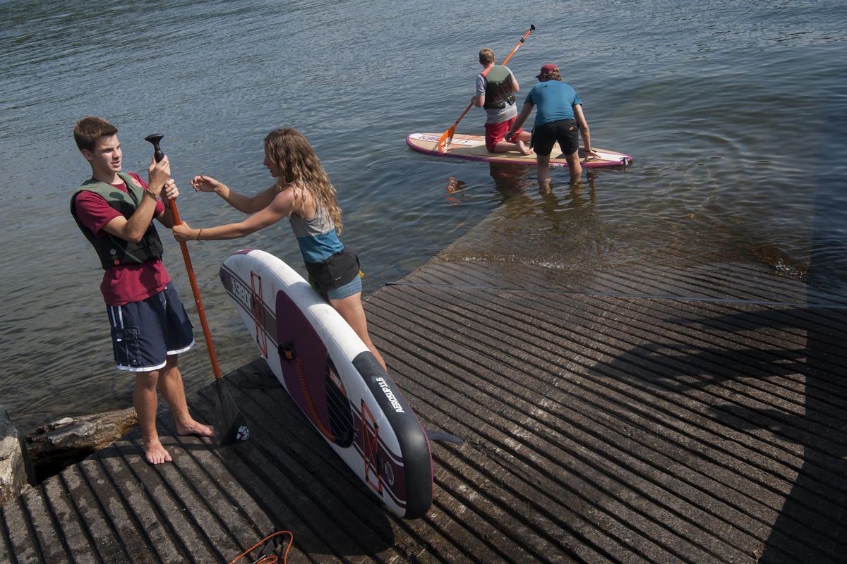 Spencer Littrel takes a paddle from Stephanie Martian, a Jobe Sports brand ambassador, as his brother Derick takes to the water at Liberty Lake boat launch. (Tyler Tjomsland / The Spokesman-Review)