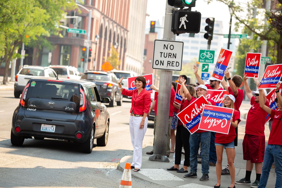 Cathy McMorris Rodgers waves to passing drivers alongside campaigners Tuesday at the corner of Monroe and Main. (Libby Kamrowski / The Spokesman-Review)