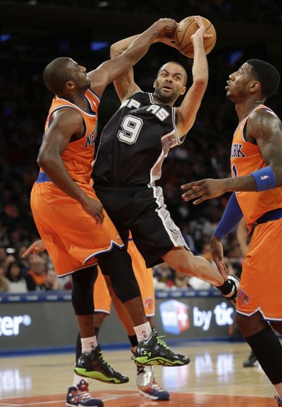 The Spurs’ Tony Parker goes between Knicks defenders Raymond Felton, left, and Iman Shumpert during the first half. (Associated Press)