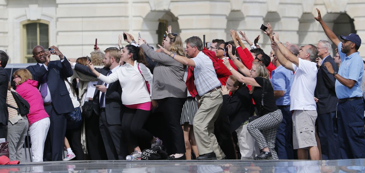 Congressional staffers and guests strain to view and photograph the departure of Pope Francis in his Fiat 500L on Thursday on Capitol Hill in Washington, D.C. (Associated Press)