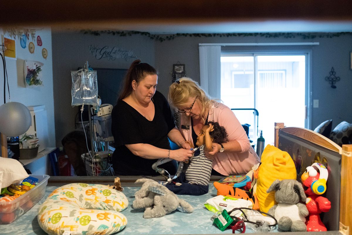 Trisha Thompson, left and CRNI Renae Wedlake work to help Thompson’s son, Trammell Armstrong, 2, with a breathing tube on Friday, May 17, 2019, at Thompson