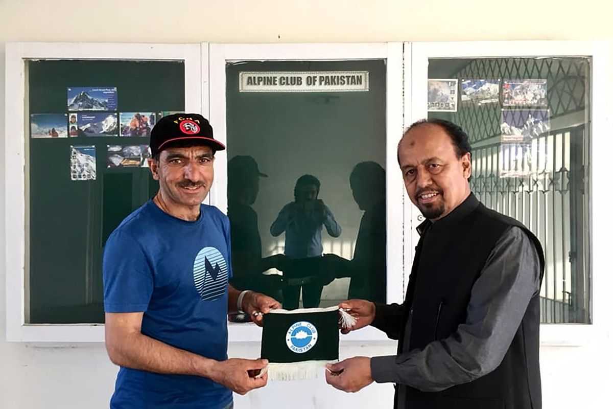 In this 2018 photo provided by Alpine Club of Pakistan shows, Pakistani mountaineer Ali Sadpara, left, receives a souvenir from Karrar Haider, a top official of Alpine Club of Pakistan, at his office in Islamabad, Pakistan. An aerial search mission is on to find three experienced climbers, Sadpara and his two companions, John Snorri and Juan Pablo Mohr, who lost contact with the base camp during their ascend on world