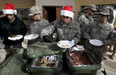 
.S. soldiers from Blackfoot Company, 2nd Battalion, 23rd Infantry Regiment, dish up their Christmas lunch at K-wal combat outpost in the village of Shakarat,  Iraq. Associated Press photos
 (Associated Press photos / The Spokesman-Review)