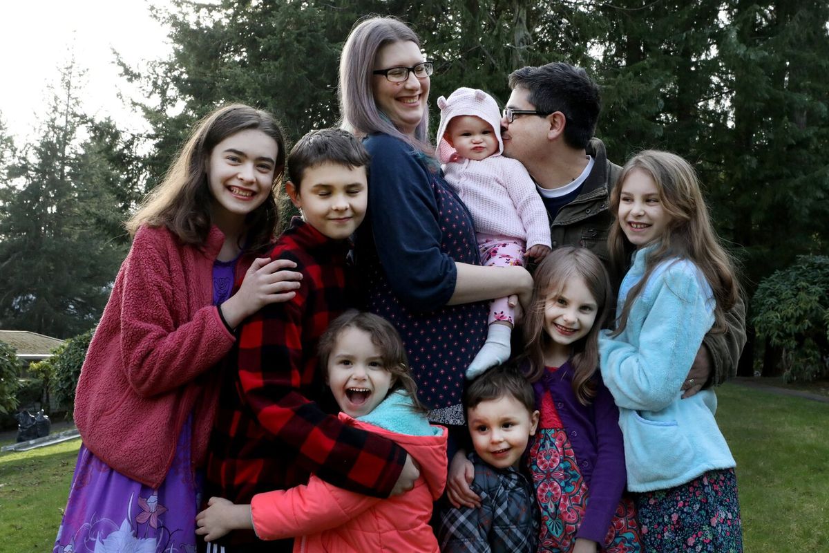 Mary and Antonio Aramburu live in Federal Way with their seven children, clockwise from top left, Milada, 15, Aviel, 13, baby Zhyana, 9 months, Kaleina, 10, Eowyn, 8, Swithun, 3, and Raziah, 5. Antonio says his bond with his family is stronger now that he doesn’t have to spend two-plus hours a day commuting.  (Alan Berner / Seattle Times)