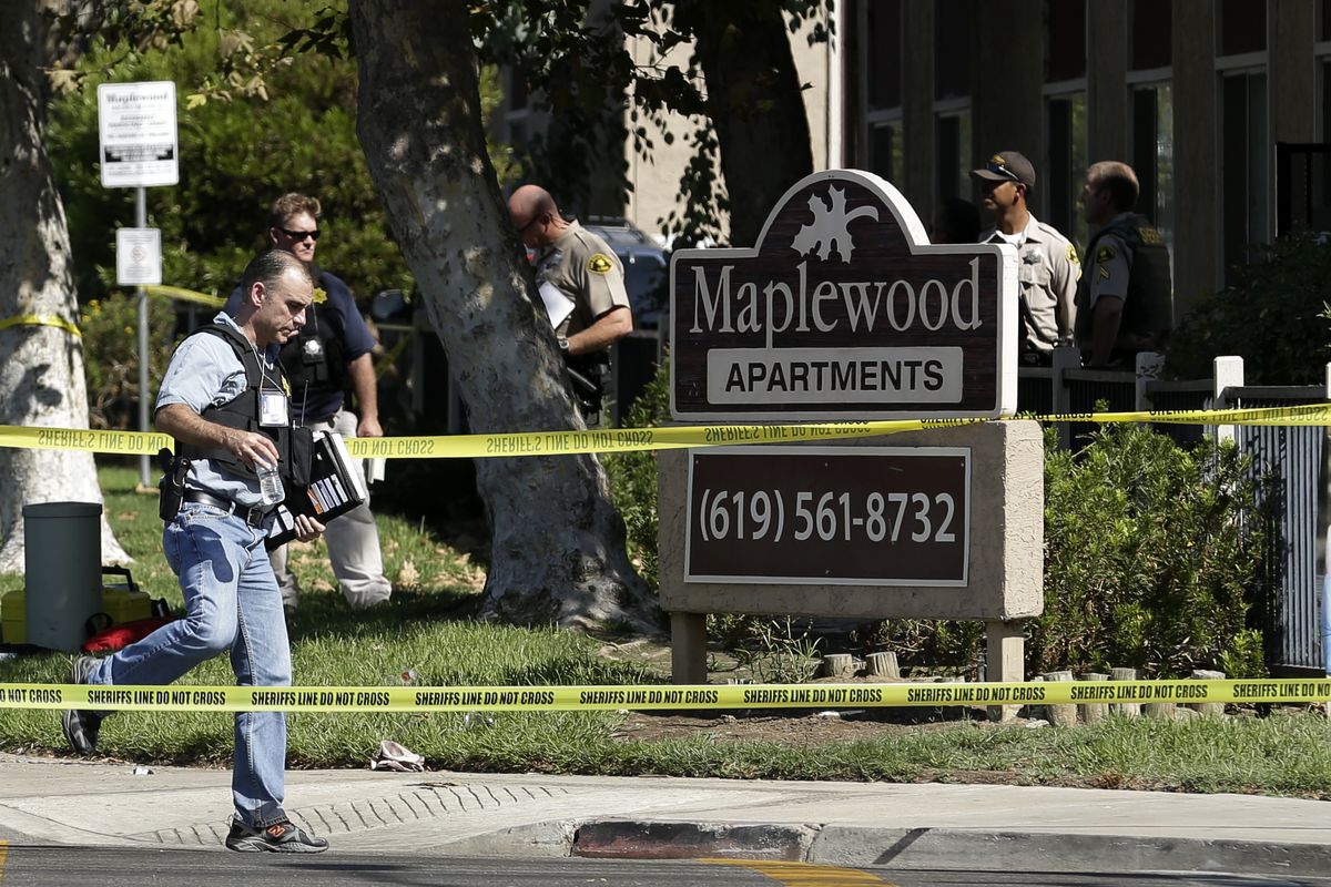 A police official walks past the Maplewood Apartments after a shooting in Lakeside, Calif. Tuesday, Sept. 25, 2012. The San Diego County sheriff