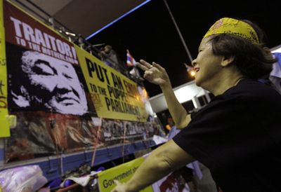 An anti-goverment protester dances in front of a poster of former Thai Prime Minister Thaksin Shinawatra at the  airport compound today in Bangkok.  (Associated Press / The Spokesman-Review)