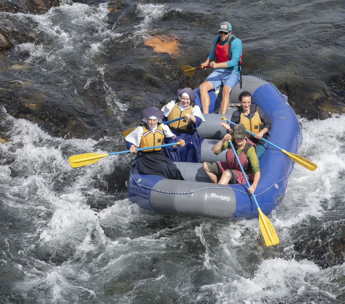 A rafting group, including nuns from Mount St. Michael, hit some whitewater with a rafting guide from Wiley E. Waters on the Spokane River near High Bridge Park on Sunday. Hundreds of inner-tubers, kayakers and others hit the river for the mostly flat-water float from Peaceful Valley or High Bridge Park to Downriver Park and Riverside State Park.  (Jesse Tinsley/The Spokesman-Review)