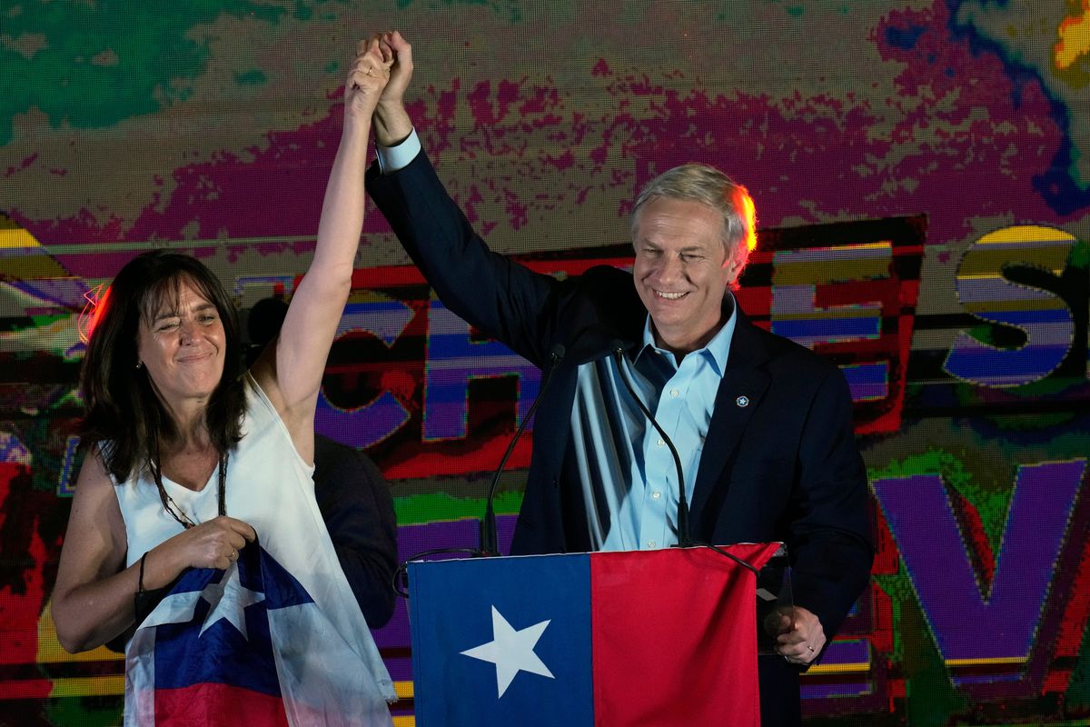 Republican Party presidential candidate Jose Antonio Kast stands before supporters with his wife Maria Pia Adriasola at his campaign headquarters after polls closed in Santiago, Chile, Sunday, Nov. 21, 2021. (Esteban Felix)