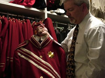 
University High band teacher Keith Nielsen holds up one of the Titans' marching band jackets with missing buttons. The band booster parents are trying to raise money to replace the 13-year-old uniforms.
 (Liz Kishimoto / The Spokesman-Review)