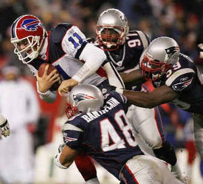 
The Patriots' Tully Banta-Cain, bottom, Rosevelt Colvin, right, and Jarvis Green add to Bills QB Drew Bledsoe's troubles on the road.
 (Associated Press / The Spokesman-Review)