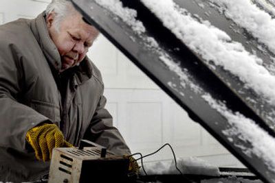 
Cold weather added to the problems Joe Benjamin had with his car parked in front of his home in Coeur d'Alene on Thursday. 
 (Kathy Plonka / The Spokesman-Review)