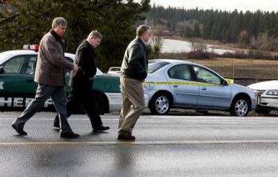
Sheriff Mark Sterk leads inspectors Larry Lindskog and Dave Wiyrick  past a Dodge Neon that was stolen from Deer Lodge, Mont., earlier this month. A sheriff's deputy shot Dustin Lowe, 29, Thursday morning near Medical Lake. Lowe was suspected in the theft of the car. 
 (Kathryn Stevens / The Spokesman-Review)