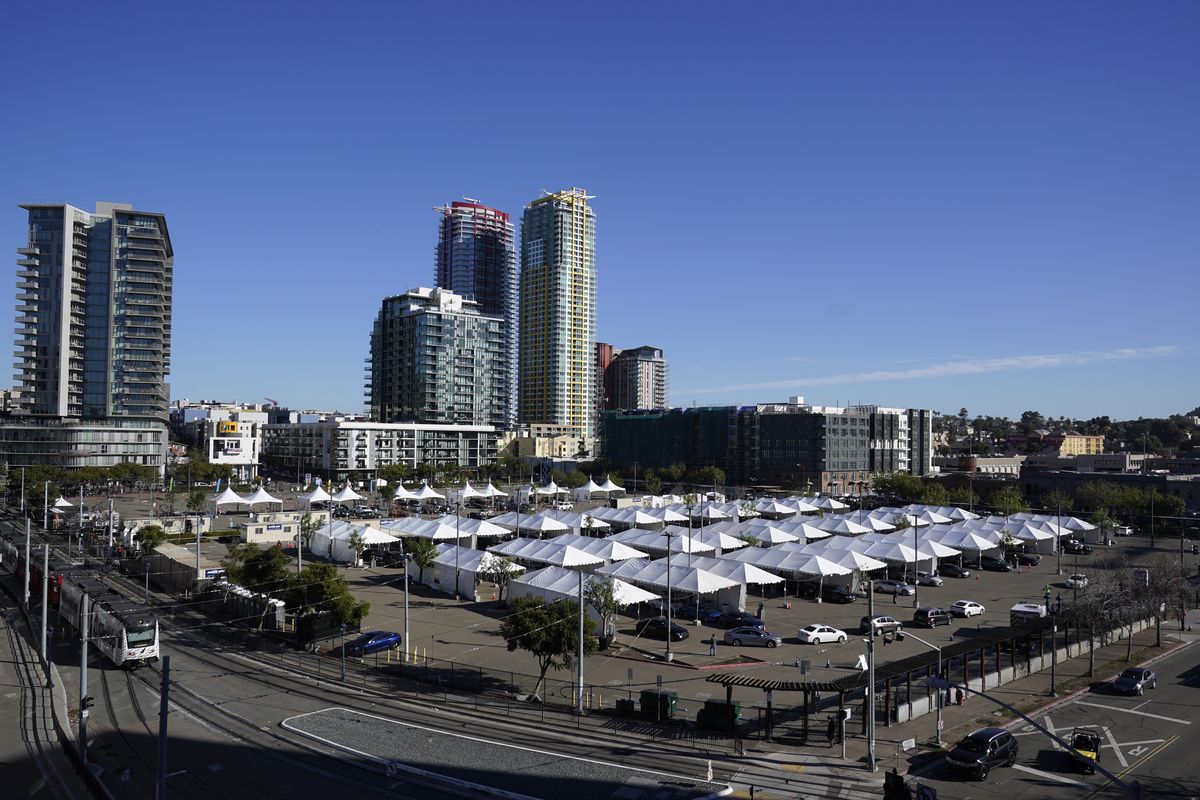 People wait in cars for a vaccination against the coronavirus at a new "vaccination superstation," Monday, Jan. 11, 2021, in San Diego. The site, which opened Monday, began providing large-scale COVID-19 vaccinations to health care workers. The U.S. is entering the second month of the biggest vaccination effort in history with a major expansion of the campaign, opening football stadiums, major league ballparks, fairgrounds, and convention centers to inoculate a larger and more diverse pool of people.  (Gregory Bull)