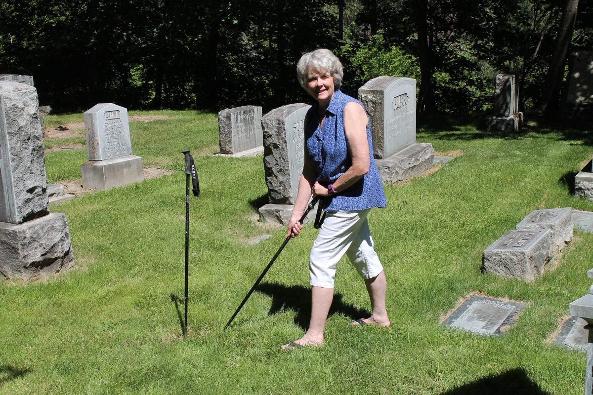 Lynn Krogh uses a sharpened ski pole to search for gravestones lost under overgrowth at Greenwood Memorial Terrace cemetery. As a member of the Eastern Washington Genealogical Society, Krogh and other volunteers help locate headstones that are sought by people from around the world. (Darin Z. Krogh / For The Spokesman-Review)
