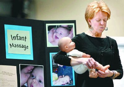 
Certified infant massage instructor Kim Harmson demonstrates a massage technique on a doll during her presentation.  
 (The Spokesman-Review)