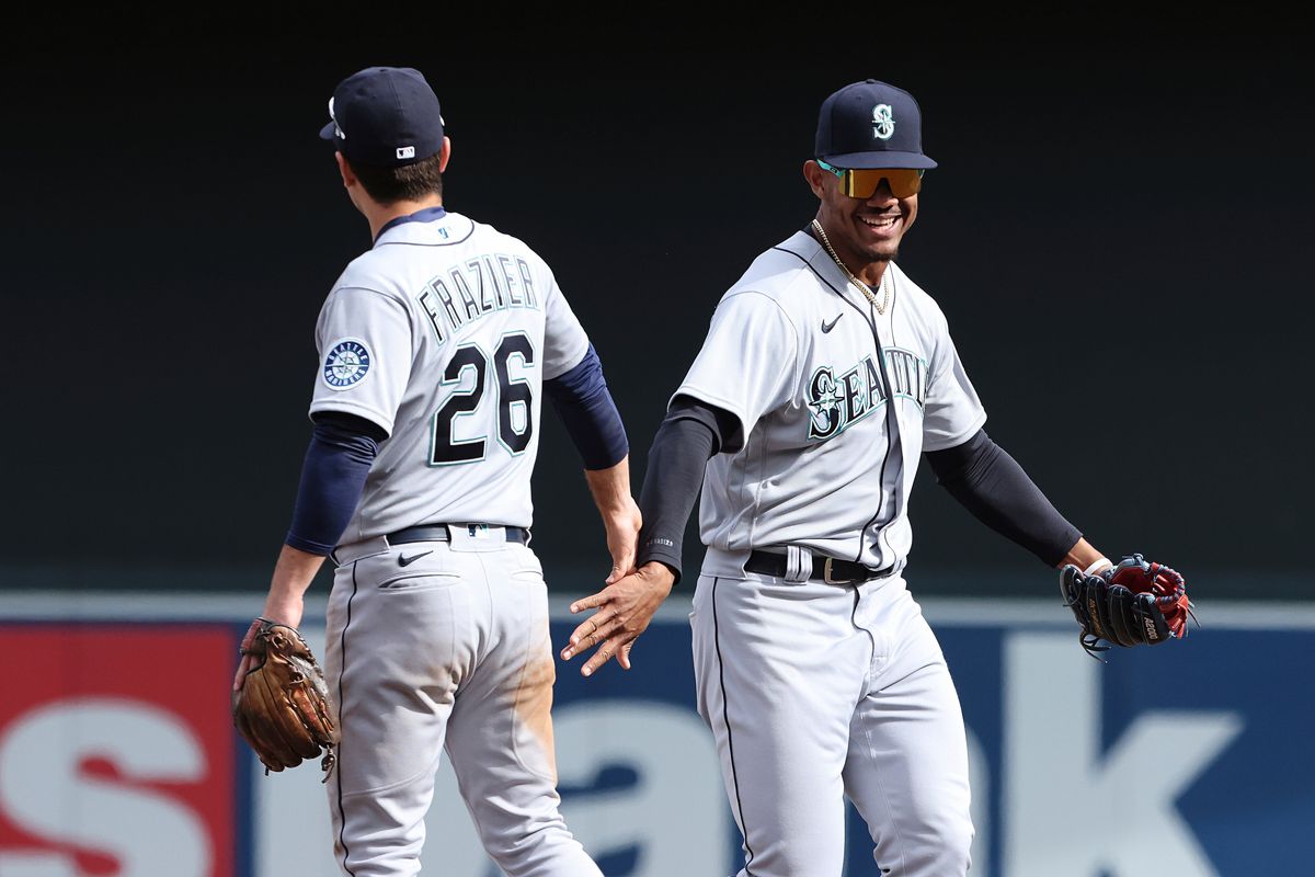 Seattle Mariners second baseman Adam Frazier (26) high fives teammate center fielder Julio Rodriguez in celebration after winning 4-3 against the Minnesota Twins after a baseball game Saturday, April 9, 2022, in Minneapolis.  (Associated Press)