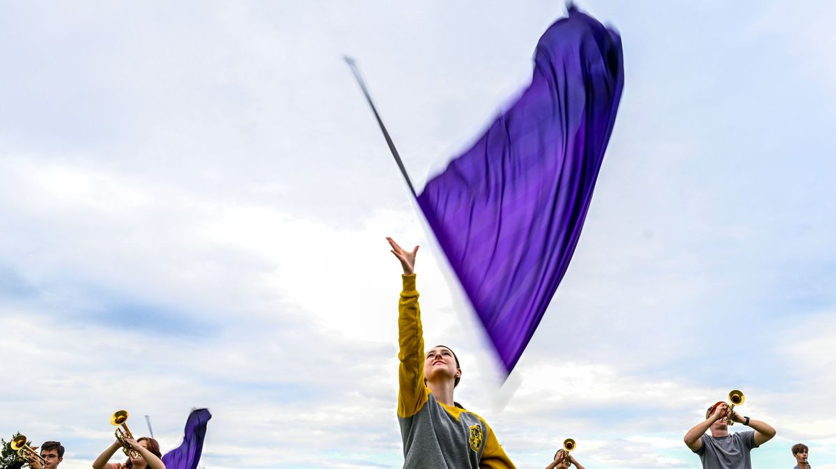 Cheney High School 10th grader Lydia Swenson tosses the flag into the air during the Cheney Marching band practice on Thu, Sep 21, 2023.  (Kathy Plonka/The Spokesman-Review)