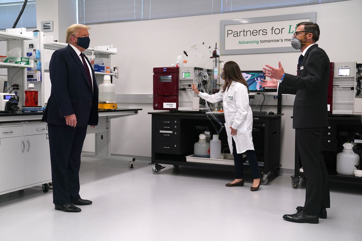 Fujifilm Diosynth Biotechnologies CEO Martin Meeson, right, speaks as President Donald Trump wears a face mask as he participates in a tour of Bioprocess Innovation Center at Fujifilm Diosynth Biotechnologies, Monday, July 27, 2020, in Morrisville, N.C.  (Evan Vucci)