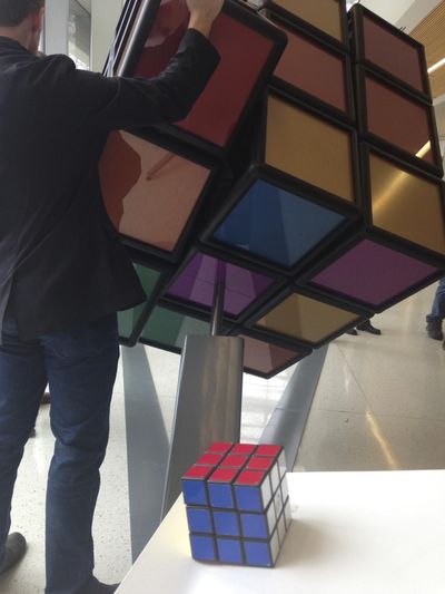 A traditional Rubik’s Cube sits on a podium in the foreground while a person operates an oversized version shortly after its unveiling inside the University of Michigans G.G. Brown engineering building in Ann Arbor, Mich., Thursday, April 13, 2017. (Mike Householder / Associated Press)