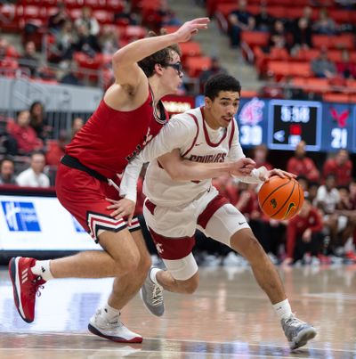 Washington State guard Myles Rice drives around Eastern Washington’s Casey Jones on Monday at Beasley Coliseum in Pullman.  (Geoff Crimmins/For The Spokesman-Review)