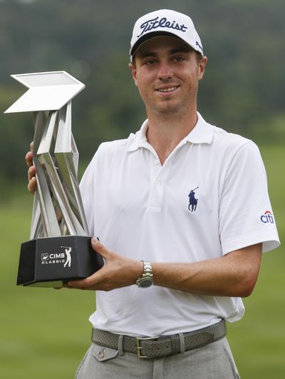 Justin Thomas of the United States poses with his trophy after winning the CIMB Classic golf tournament at Kuala Lumpur Golf and Country Club in Kuala Lumpur, Malaysia on Sunday. (Joshua Paul / Associated Press)