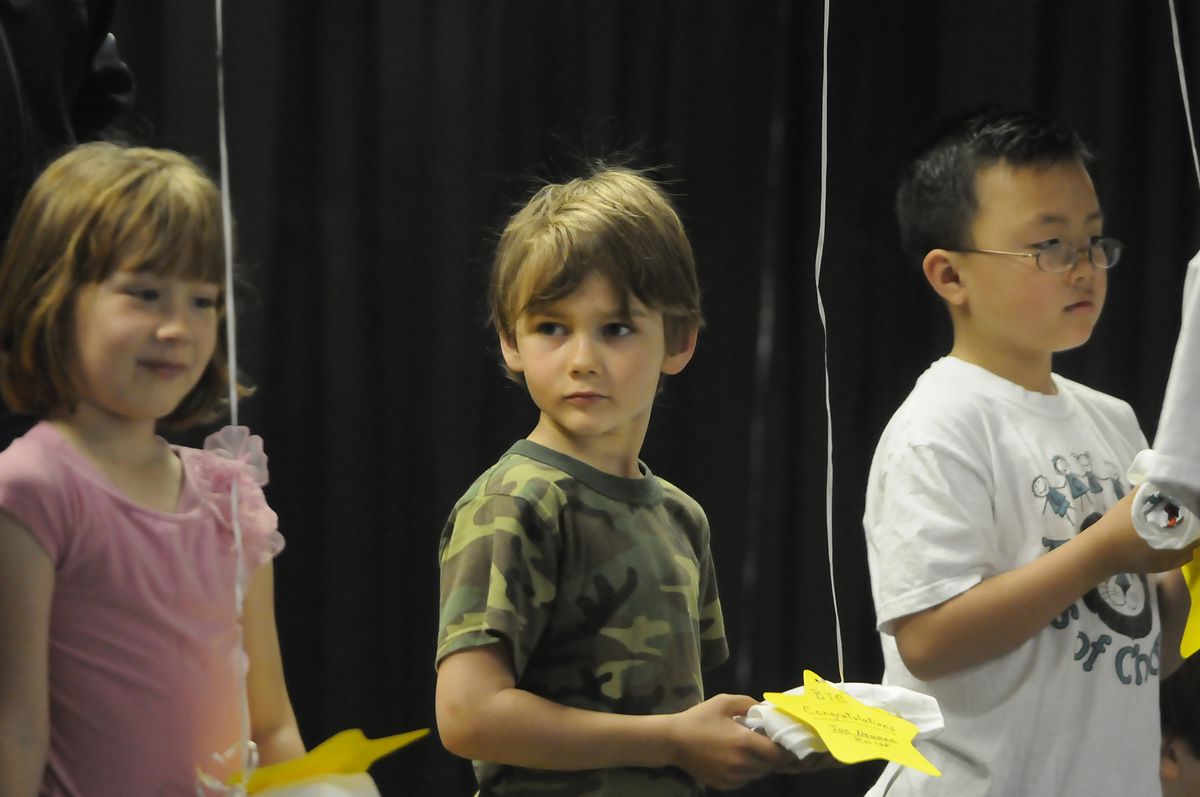 From left, first-grader Jaylynn Maxey, kindergarten student Jacson Newman and second- grader Anthony Phung hold their recognition gifts. (Jesse Tinsley / The Spokesman-Review)