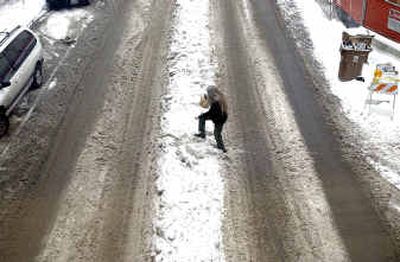 
Kay Bisaro maneuvers her way over a snow berm on Howard Street between Riverside and Sprague Avenues Monday afternoon. 
 (Kathryn Stevens / The Spokesman-Review)