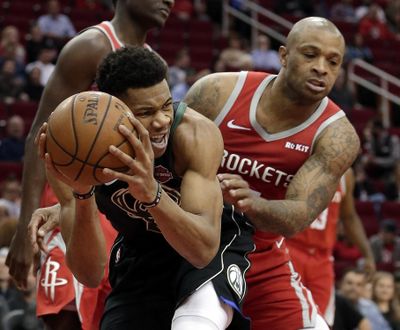 Milwaukee Bucks forward Giannis Antetokounmpo, left, protects his rebound from Houston Rockets forward PJ Tucker, right, during the first half of an NBA basketball game Wednesday, Jan. 9, 2019, in Houston. (Michael Wyke / Associated Press)