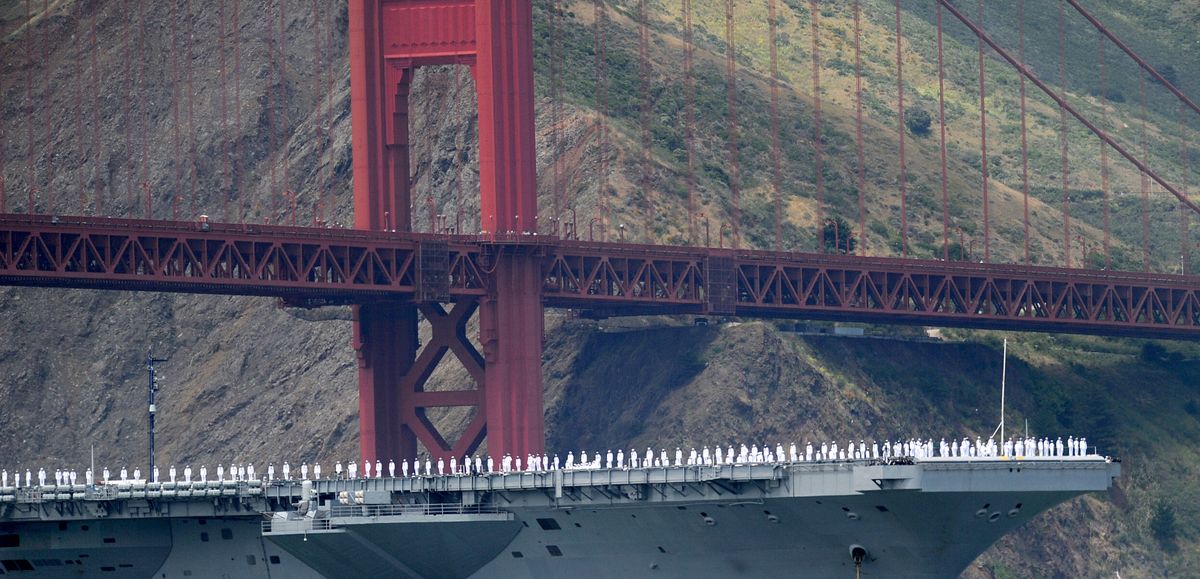 With sailors on deck, the USS Nimitz passes beneath the Golden Gate Bridge on Sunday during a celebration of the bridge’s 75th anniversary. (Associated Press)