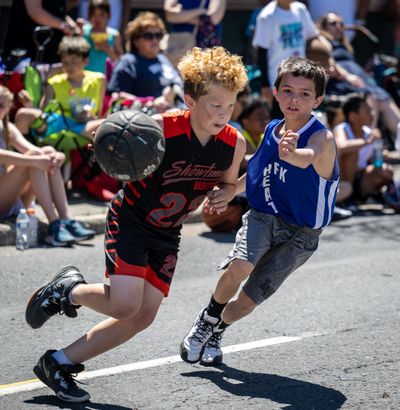 Team It’s Showtime’s Lorenzo Hewitt, 9, on left with ball, drives to the basket as team HFK Heat’s Ty Crispo, 9, defends during their game on Stevens Street.  (COLIN MULVANY/THE SPOKESMAN)