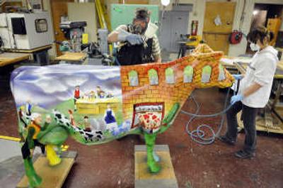 
Shadle Park technology instructor Ray Harding sprays a clear coat onto the artwork of student Jeayoung Yoo on March 26. Yoo is a finalist  in Lucerne's The Art of Dairy Cow Sculpture national contest. 
 (Dan Pelle / The Spokesman-Review)
