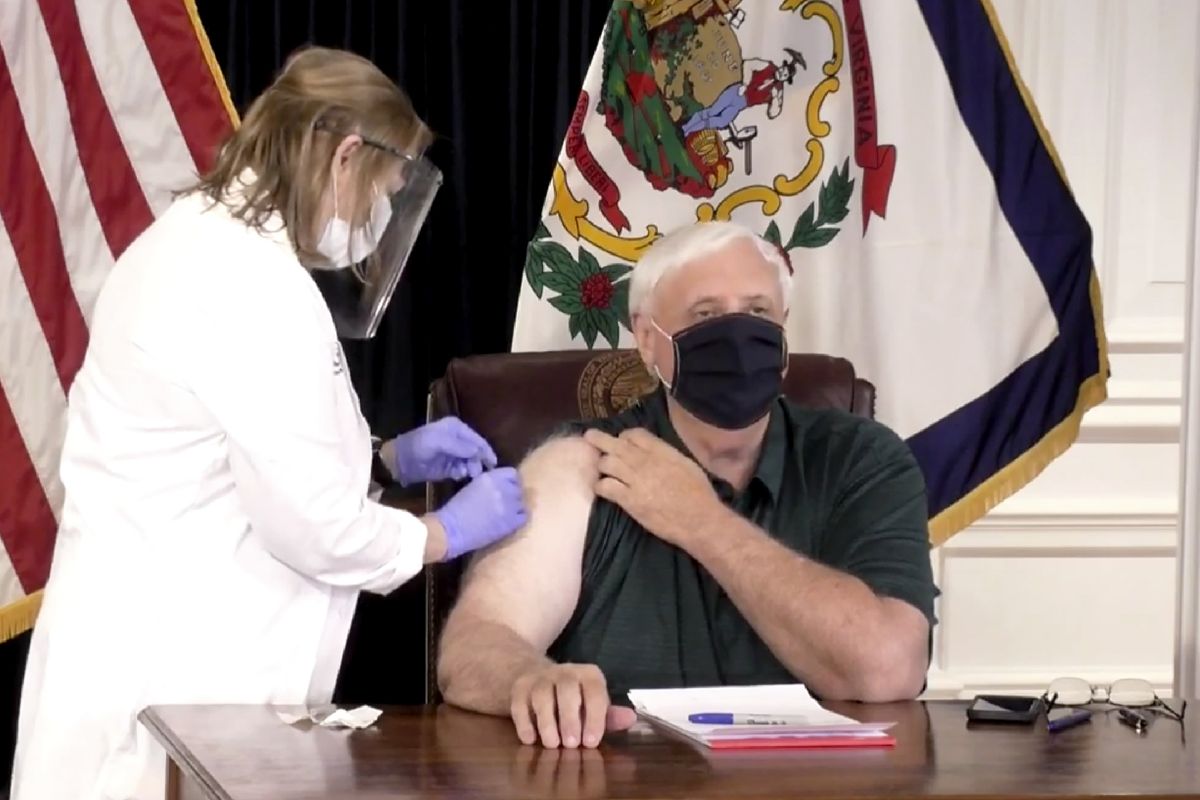 In this image made from video released by the State of West Virginia, a nurse administers a coronavirus shot to west Virginia Gov. Jim Justice, Monday, Dec. 14, 2020, in Charleston, W.Va. The 69-year-old Republican governor said he would receive a shot before cameras which would make him one of the first top elected officials in the country to get vaccinated. Officials said they want to demonstrate their confidence in the vaccine.  (HOGP)