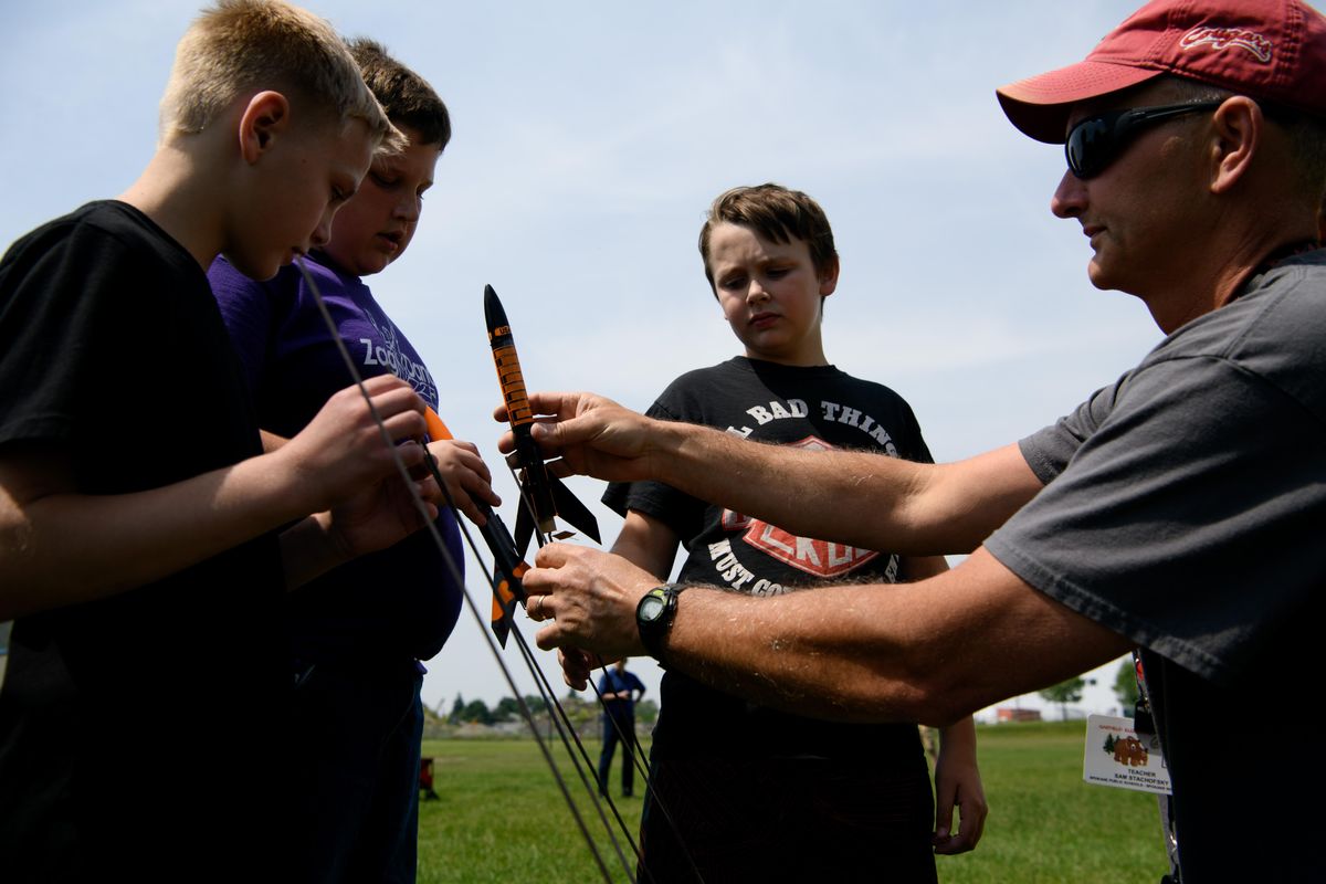 Teacher Sam Stachofsky helps his students prepare their rockets for launch on Tuesday, June 4, 2019, at Andrew Rypien athletic field in Spokane, Wash. The rocket launch was part of a STEM rocket program at Garfield Elementary School which is sponsored by The Rotary Club. (Tyler Tjomsland / The Spokesman-Review)