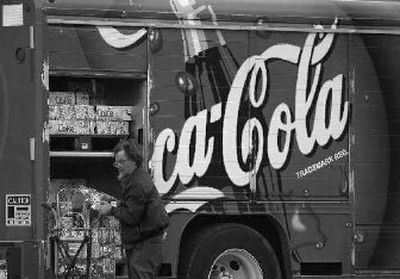 
A driver stacks Coca-Cola products for delivery at a mini-mart service station in Chagrin Falls, Ohio. 
 (File Associated Press / The Spokesman-Review)